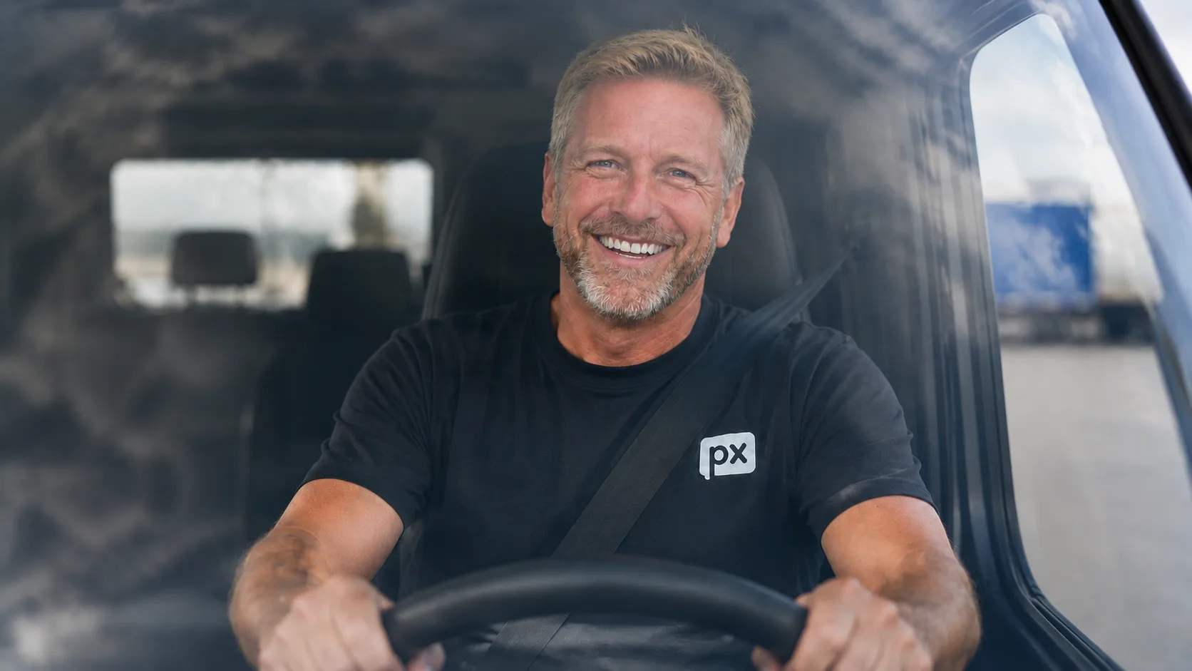 Smiling truck driver at the wheel